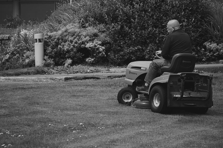 Professional riding lawn mower on a large green lawn
