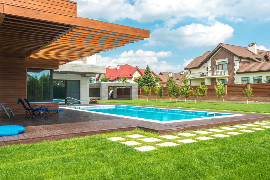 Beautiful backyard landscape with fresh green grass and stone patio